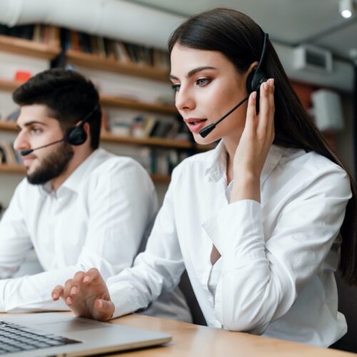 beautiful woman works in call center with headset answering client phone calls