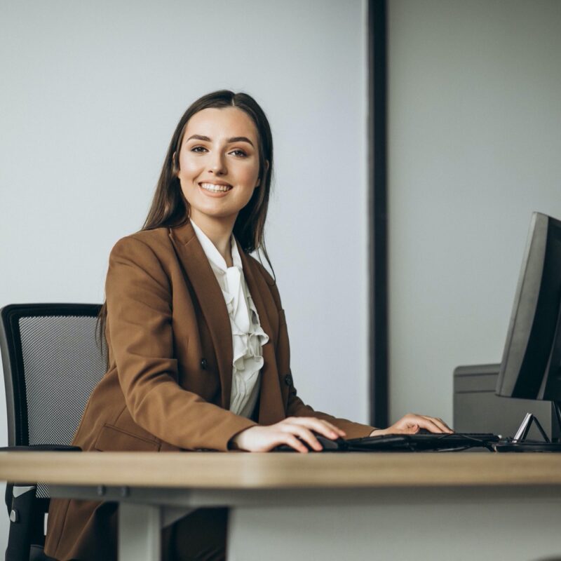 Young business woman working on laptop in office